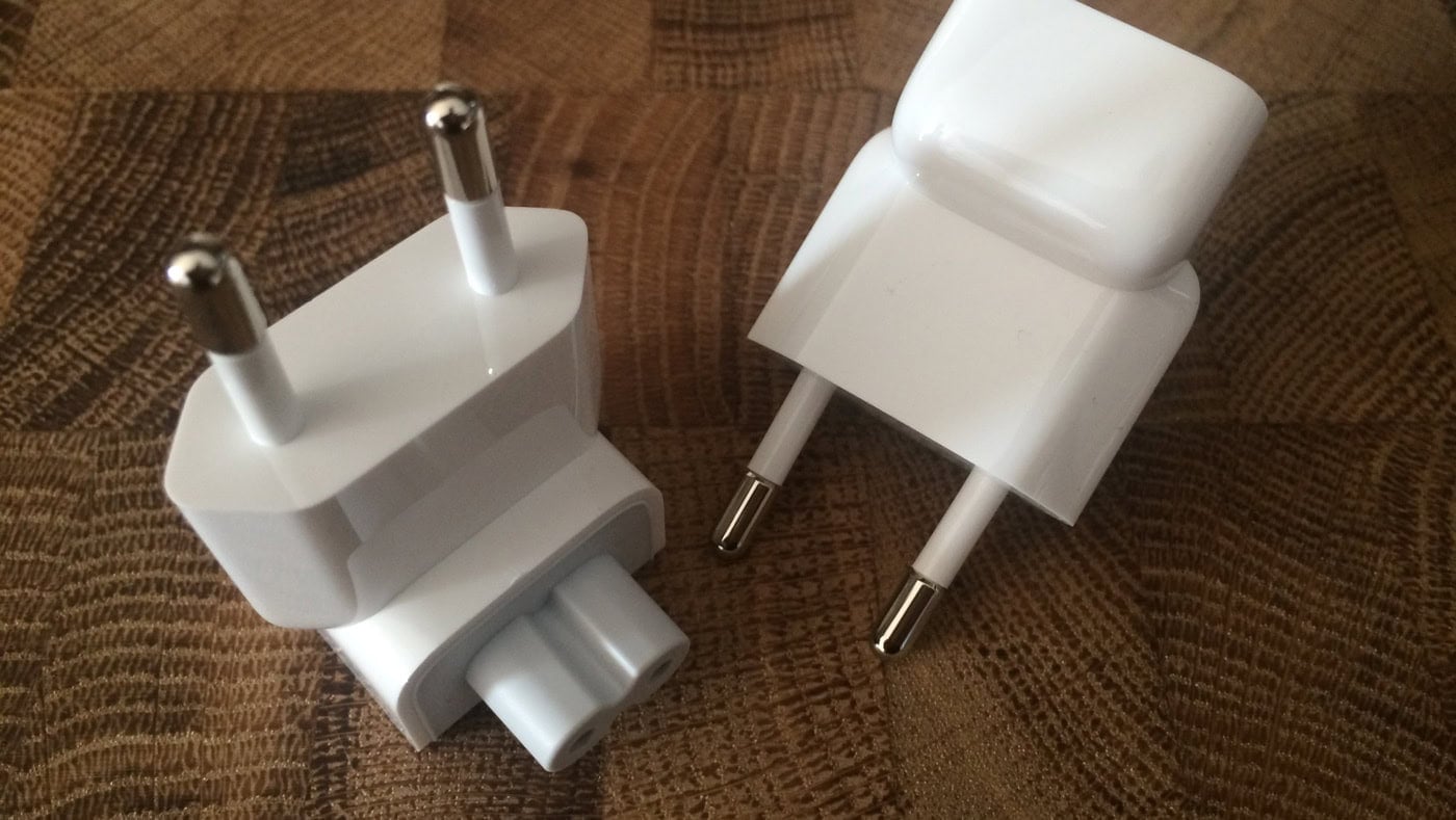 Zwei weiße Netzadapter mit Eurostecker auf Holztisch