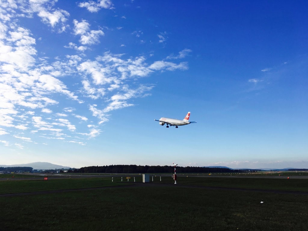 Passagierflugzeug im Landeanflug über Flughafenpiste bei blauem Himmel