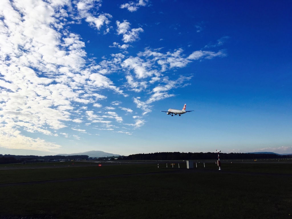 Passagierflugzeug landet vor blauem Himmel mit Wolken