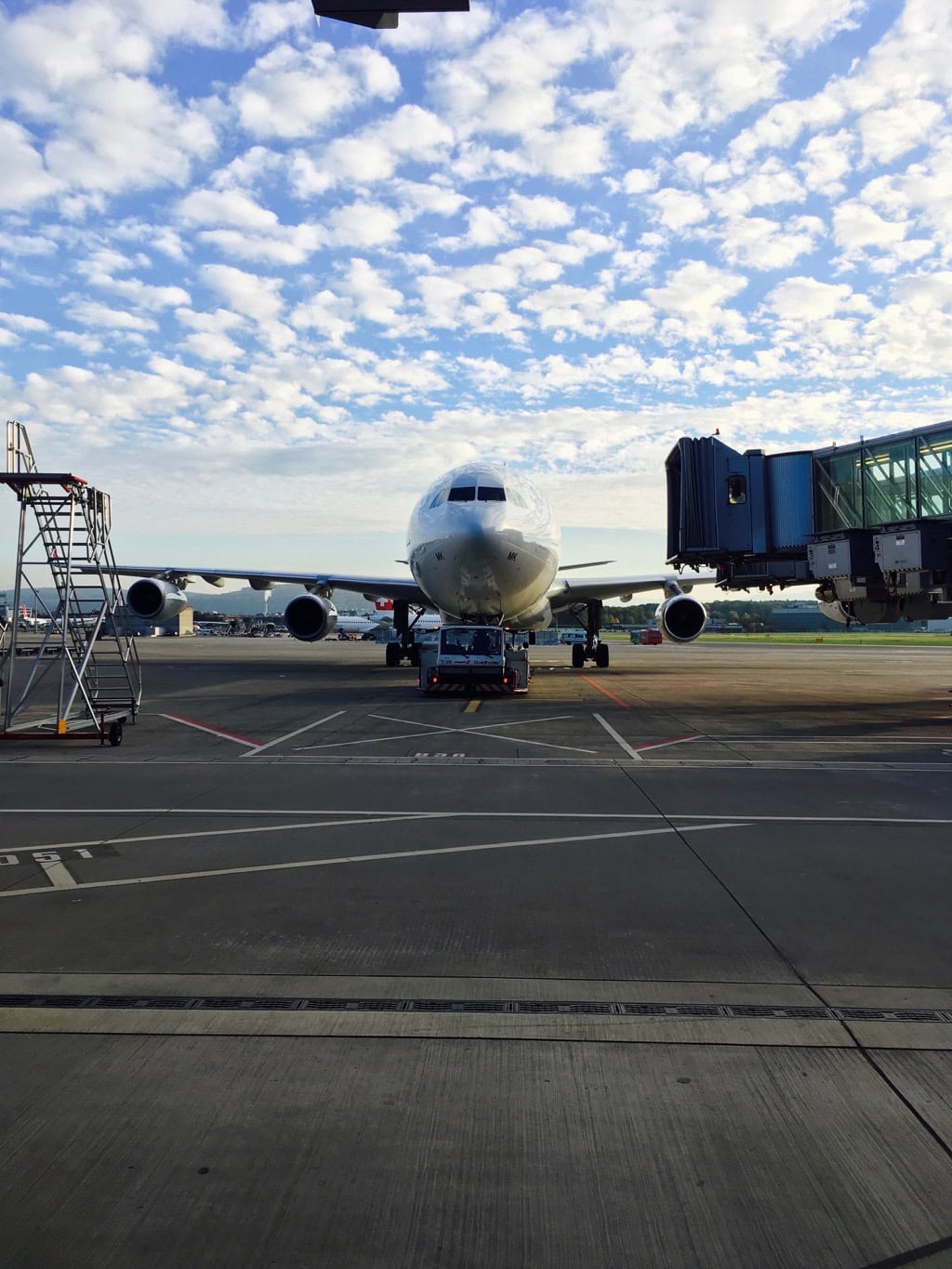 Passagierflugzeug an Flughafen-Gate unter wolkigem Himmel