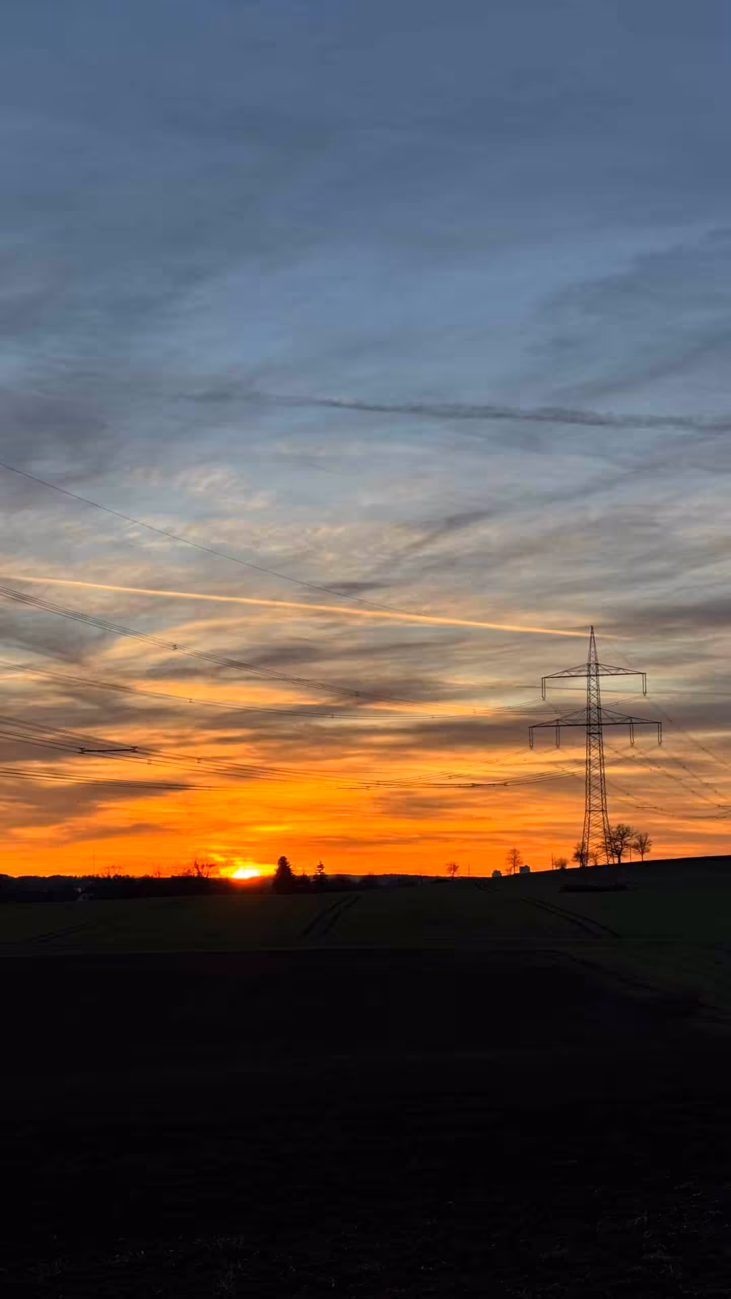 Sonnenuntergang mit Strommast und Wolken