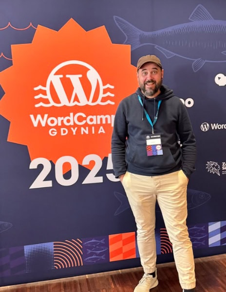 Christopher Kurth steht vor WordCamp Gdynia 2025 Konferenzwand